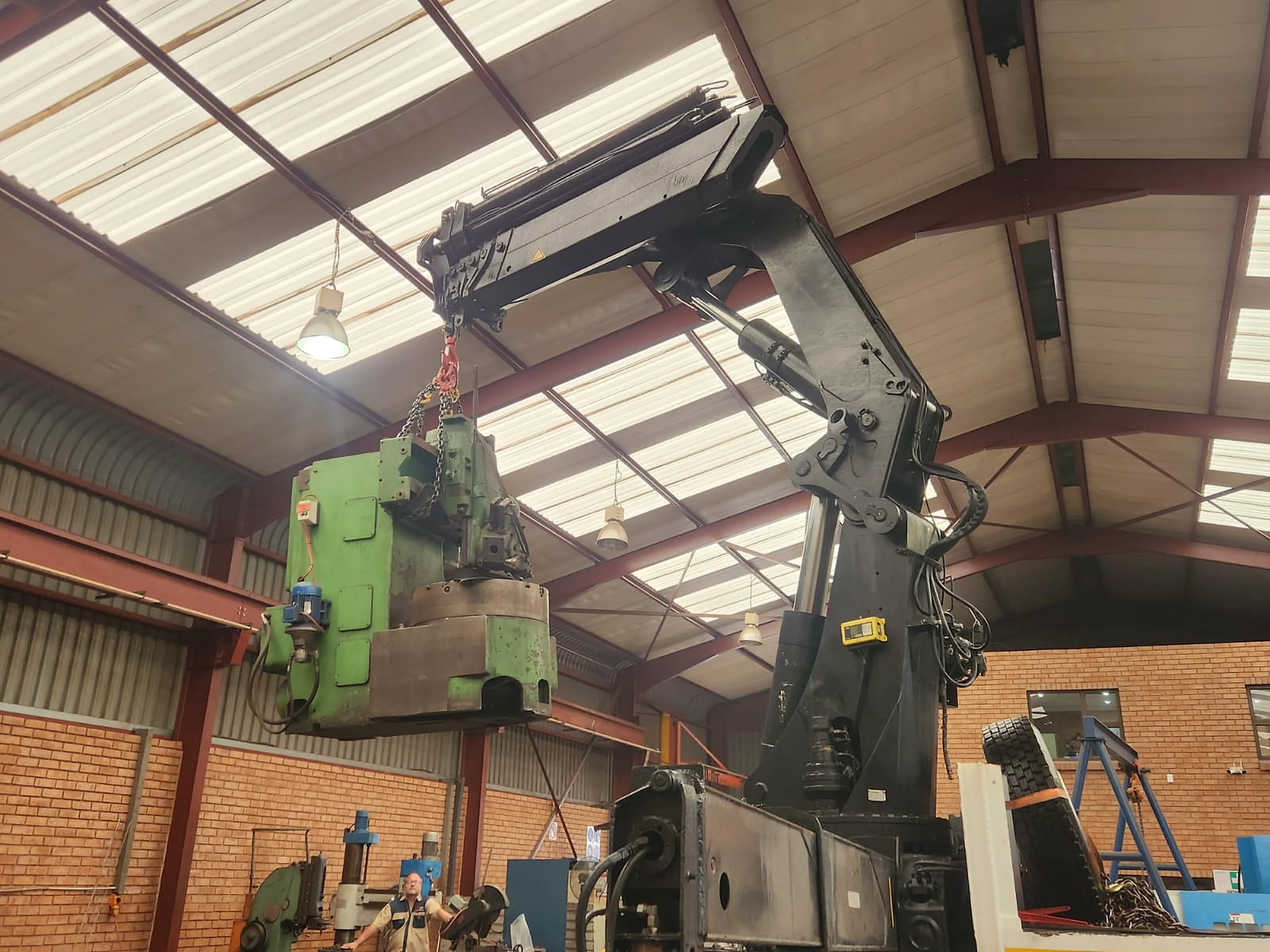 Industrial machine being lifted inside a production facility