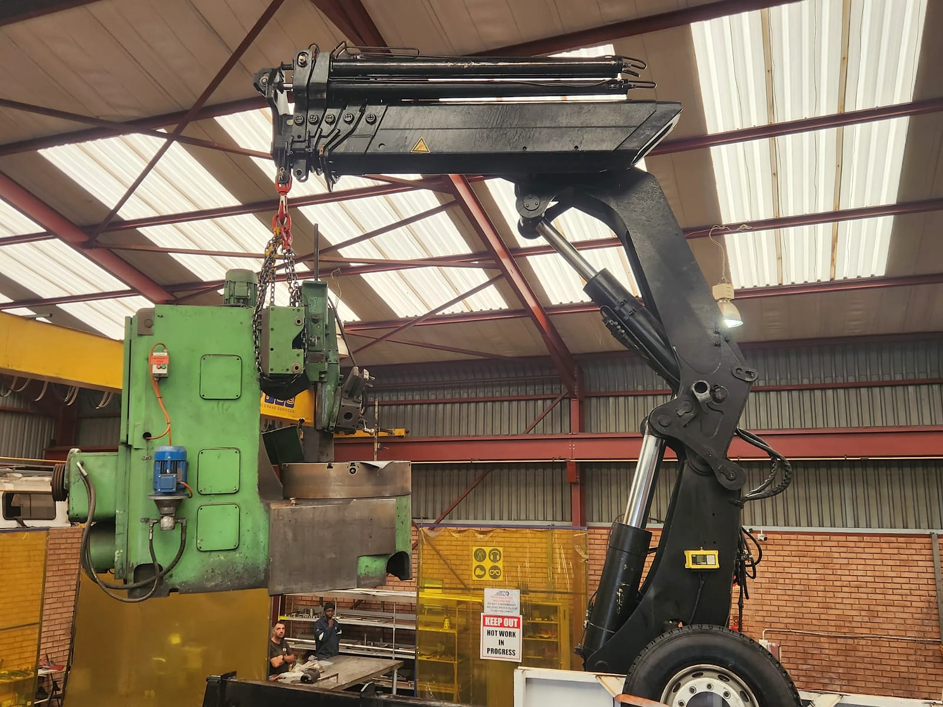 Industrial machine being rigged and positioned indoors