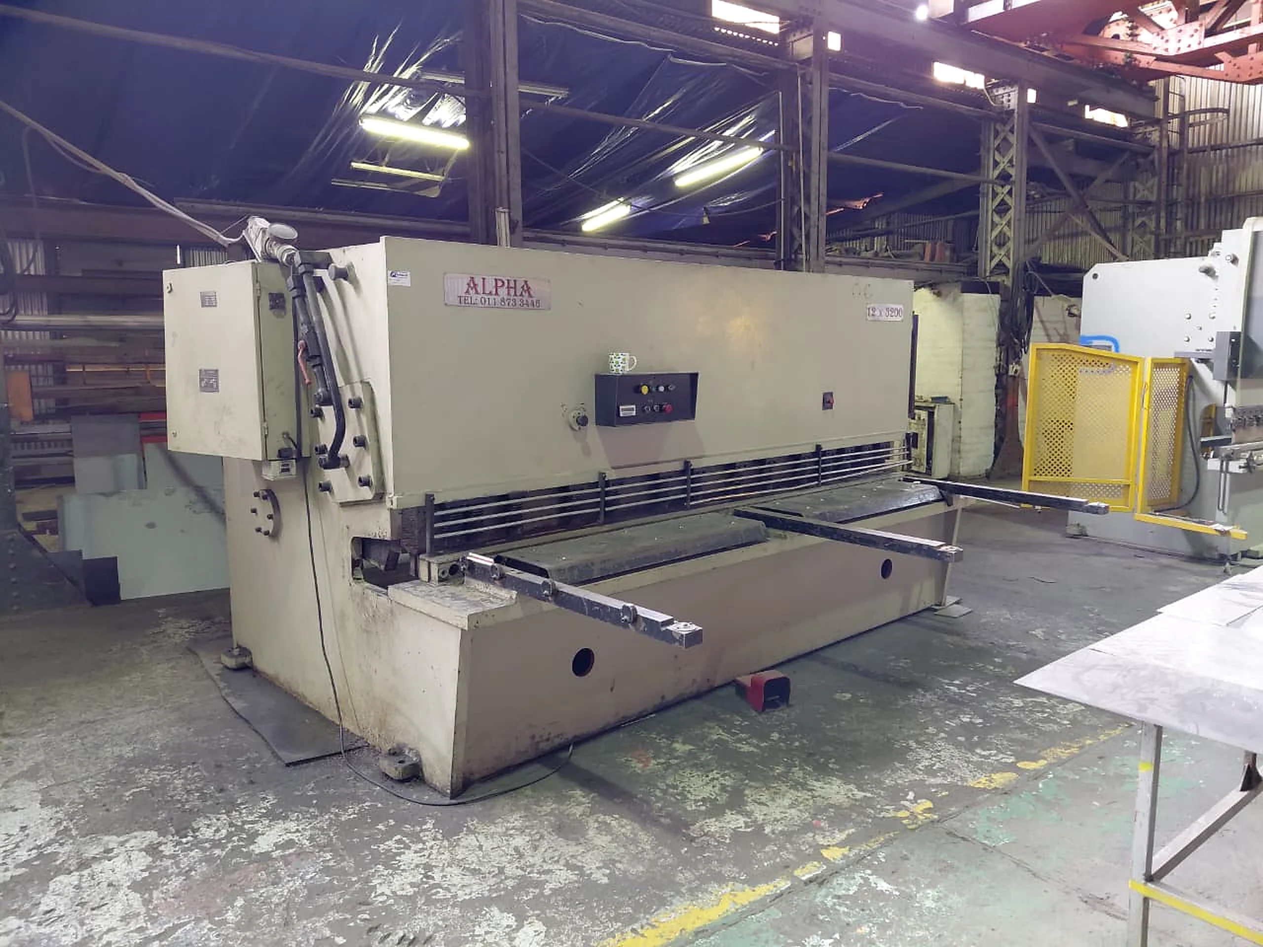 Industrial guillotine machine in a maintenance workshop