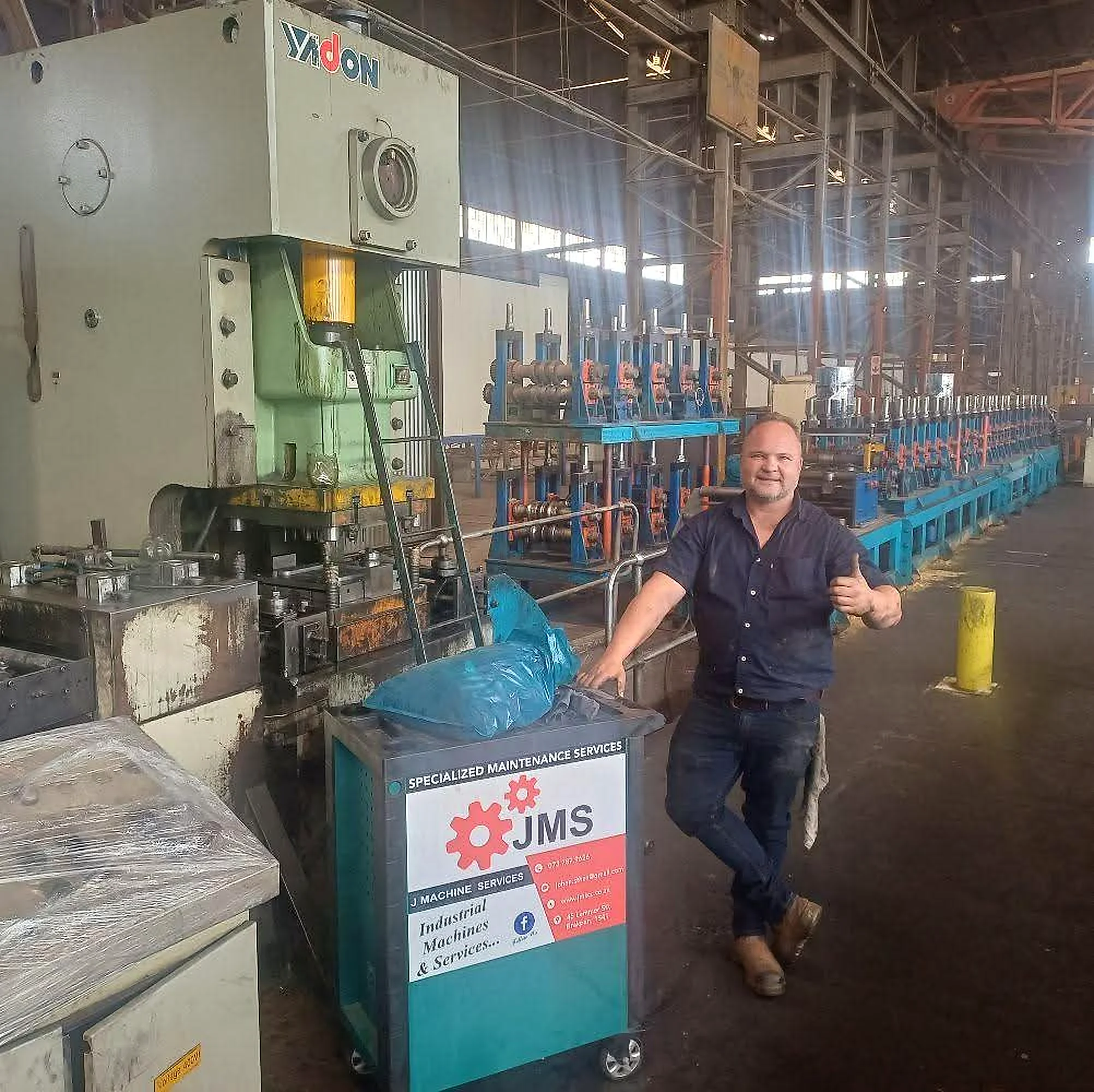 Werk Maak Sterk engineering technician working beside industrial machinery